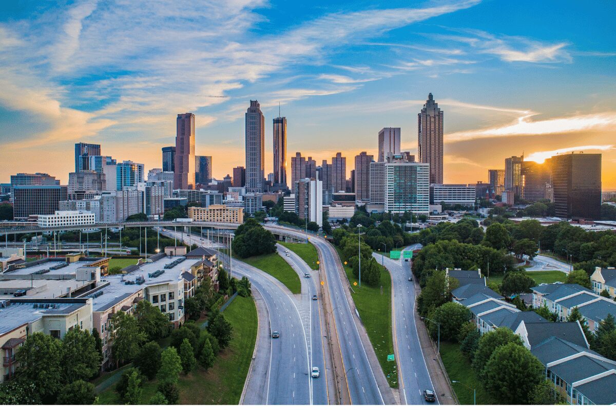 Atlanta, Georgia, skyline at sunset with commercial high-rise buildings, highways and surrounding neighborhoods.