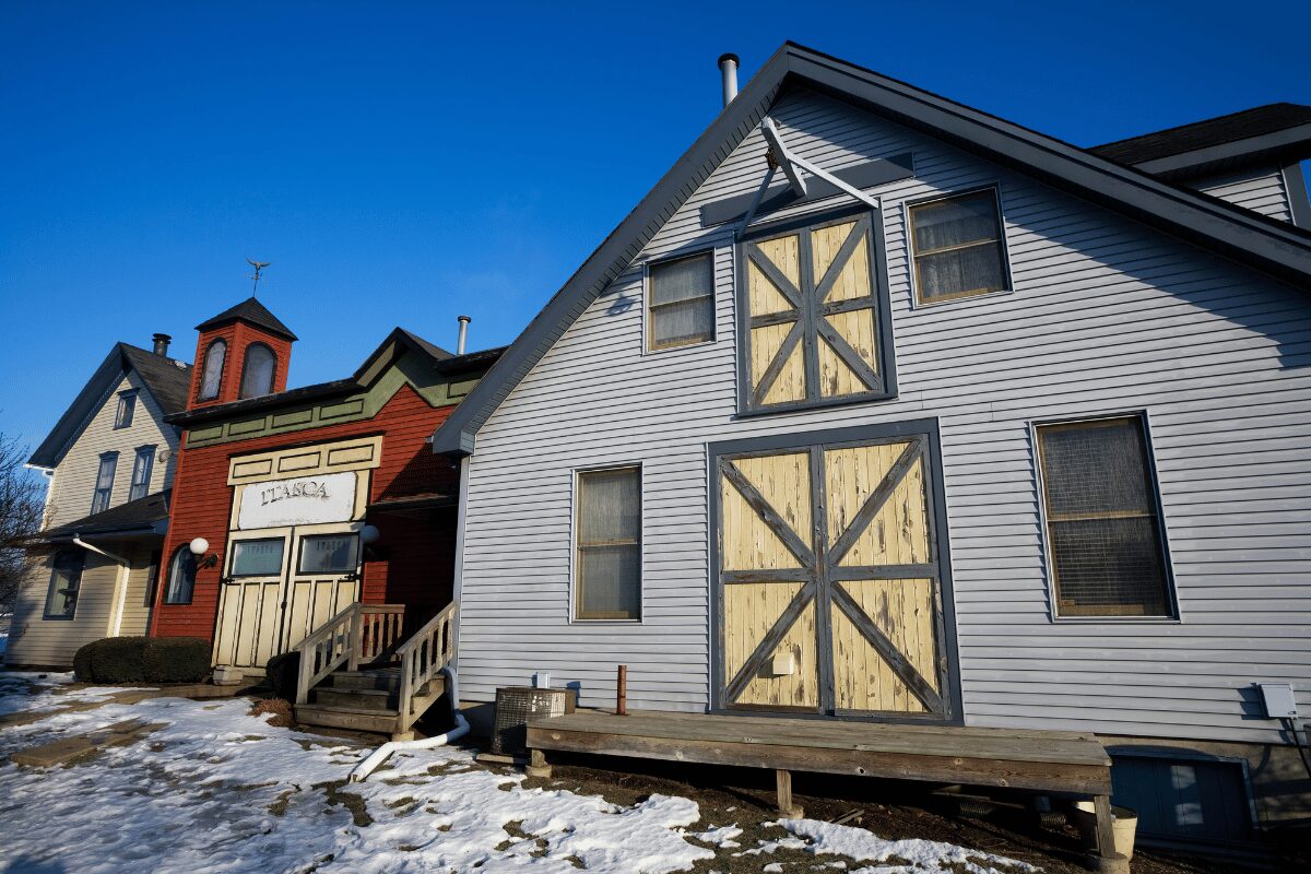 Historic buildings in Itasca, Illinois, with wood siding, pitched roofs and patches of winter snow.