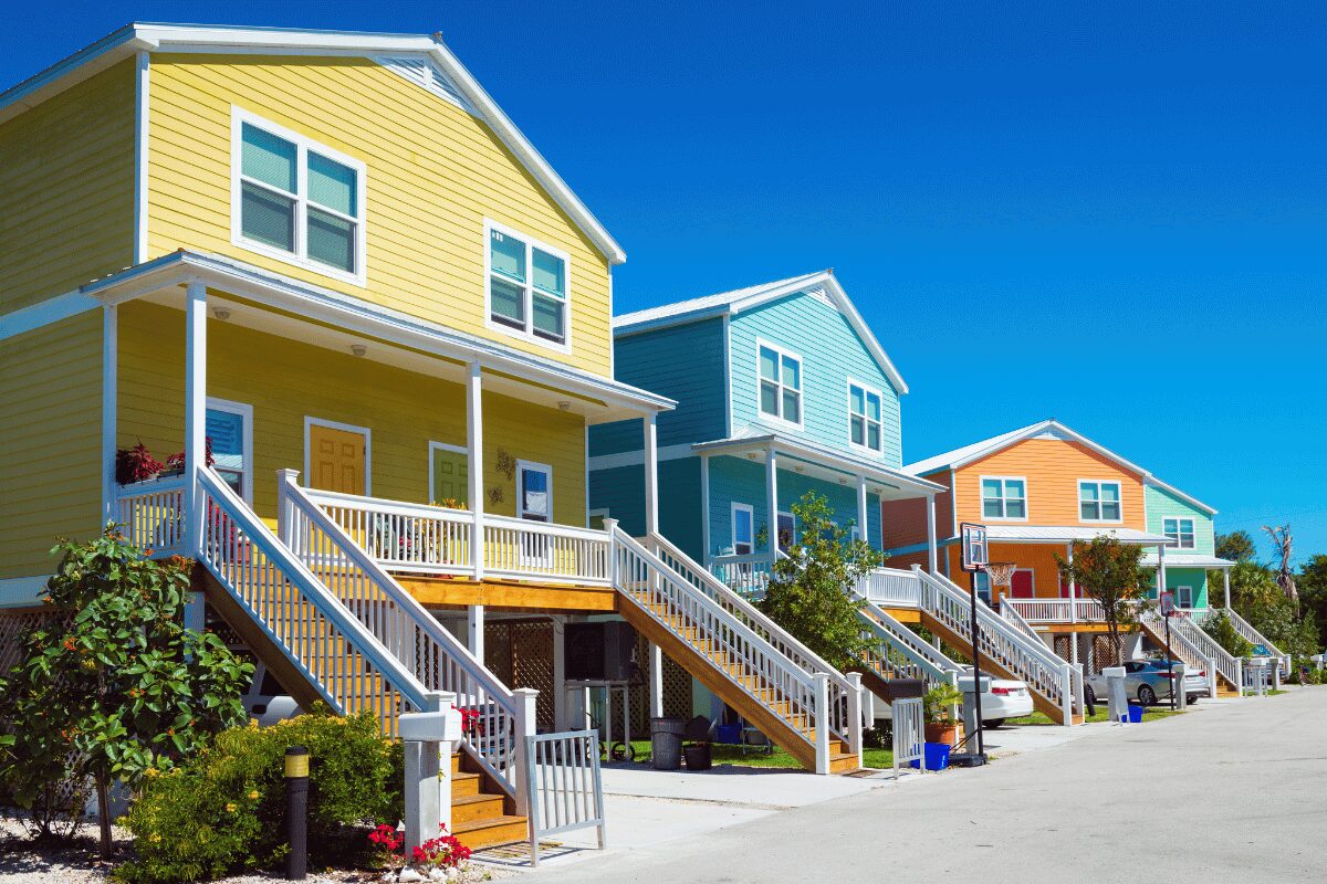 Colorful elevated homes in Key West, Florida Keys, with covered porches, exterior stairs and metal roofs.